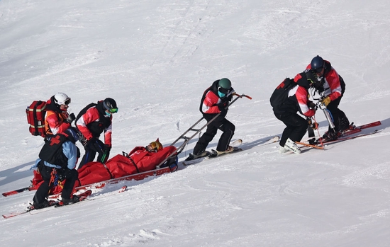 在延庆国家高山滑雪中心，高山滑雪医疗队队员用雪橇船将选手带离赛道救治。