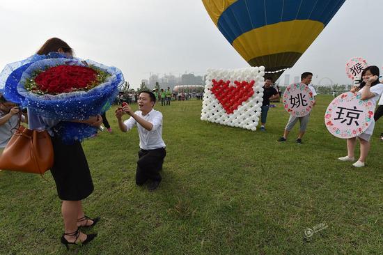 

6月10日下午，合肥滨湖岸上草原上演了一场热气球求婚仪式。小伙欧阳健乘坐热气球向女友姚琼求婚，并上交工资卡、车钥匙和购房合同，现场吸引了数百名游玩的市民。