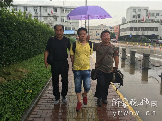 嫌疑人李某被刑警押解返回山东。