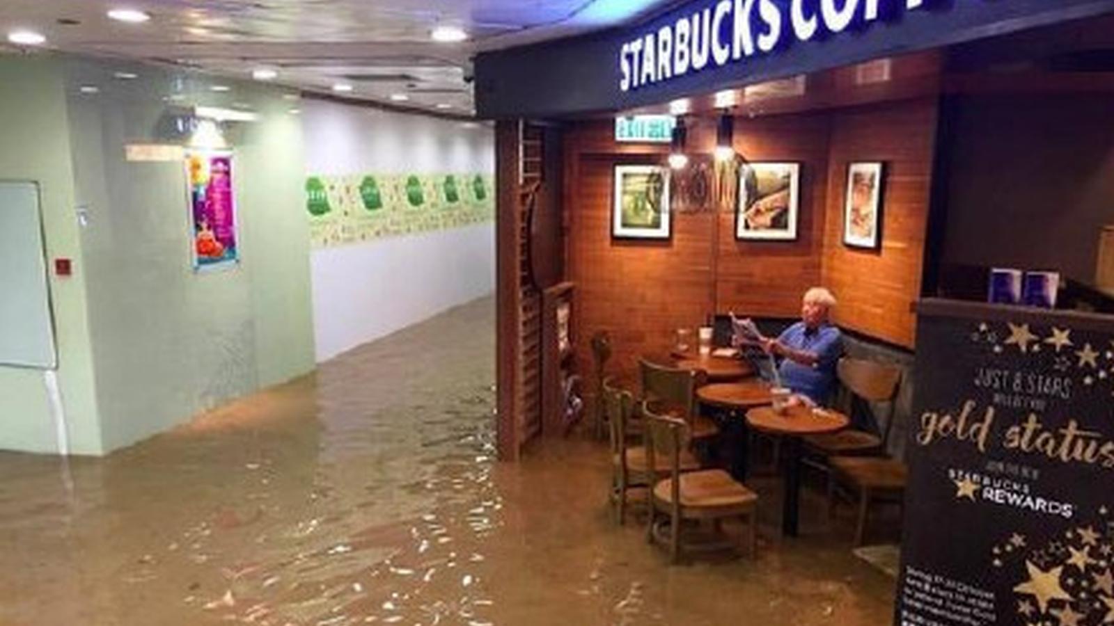 台风袭击香港 老伯水中淡定看报走红网络