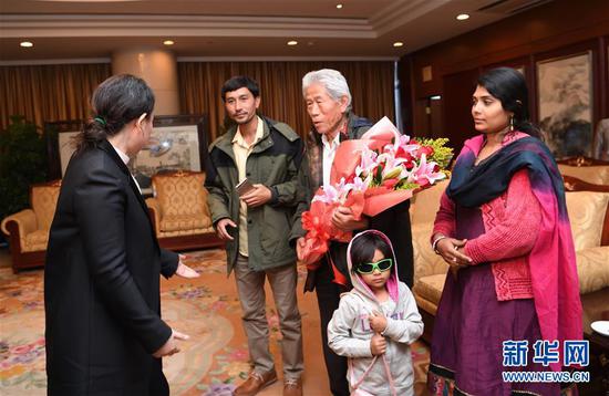 2月11日，在印度滞留50多年的中国老人王琪（中）抵达北京首都国际机场，顺利回国。