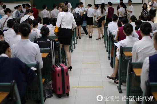 一位面试者从外地赶来珠海，身旁放着行李箱。
