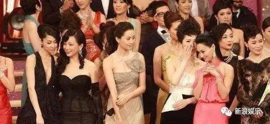 这张图诞生的背景就是在 10 年 TVB 台庆上，当年还是三色台二线的胡定欣被邓萃雯拉到了前一排，然后产生了那张杨怡耸肩白眼的图。