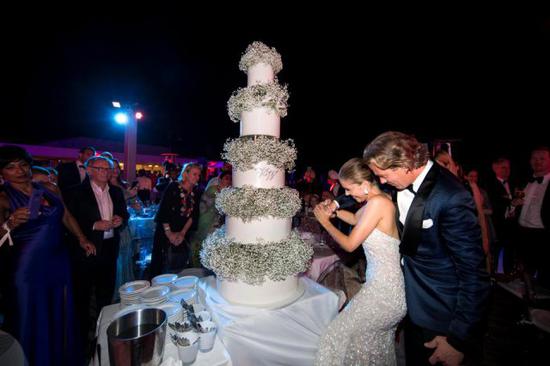 婚礼后一对新人在五星级度假酒店举行派对庆祝，切了一个五层高的婚礼蛋糕，派对结束时进行了烟火表演。