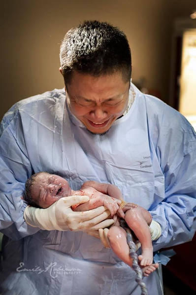 这位父亲抱着刚出生的孩子，激动不已。