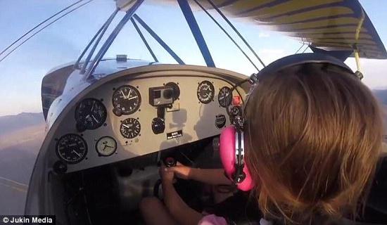 小女孩握着飞机操作杆在做复杂的飞行动作