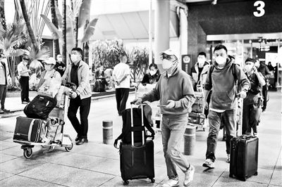 在海口美兰国际机场T1航站楼，乘客推着行李箱快速通过机场出口供图/视觉中国