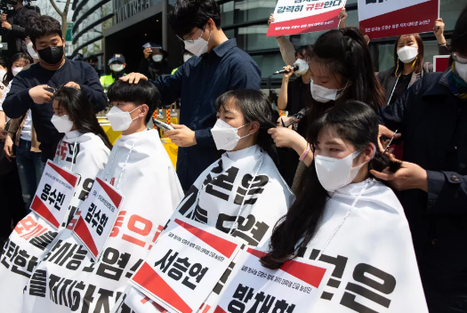 “韩国大学生进步联合”的成员今天在日本驻韩大使馆前集体削发，抗议日本政府的决定。来源：GJ