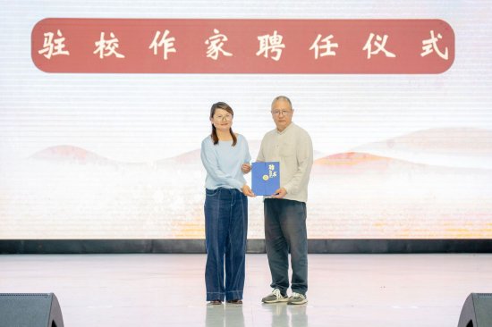 图注：胡性能在体育馆现场受聘为云南工商学院驻校作家
