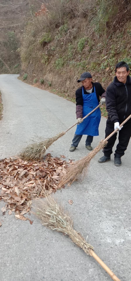 图为村保洁员清扫道路