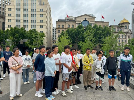 同学们在上海外滩听导游讲述外滩故事