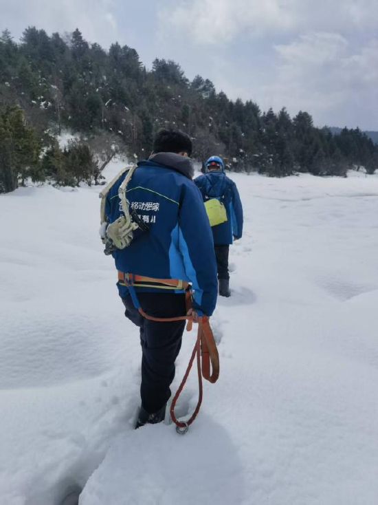工作人员在雪地中前行（2026年3月25日摄）