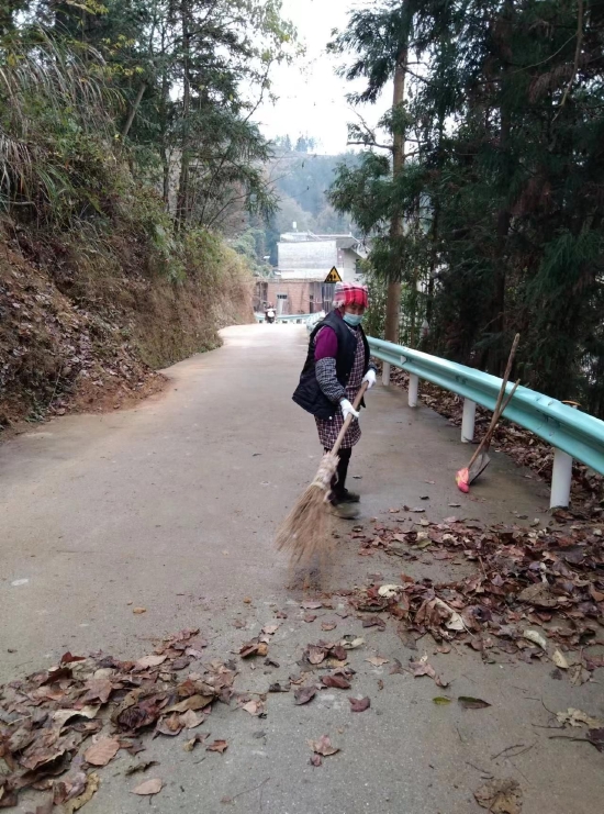 图为村保洁员清扫道路