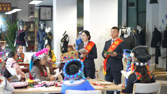 金融宣传员为绣娘讲解“彝绣贷”等普惠金融政策，拍摄人：段雅芳