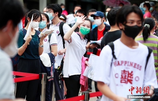 资料图:一名考生在进入考场前向家长挥手致意。中新社记者 汤彦俊 摄