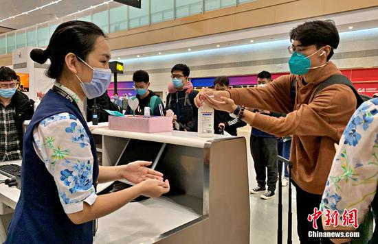 图为留学生进行消毒。 重庆机场集团供图