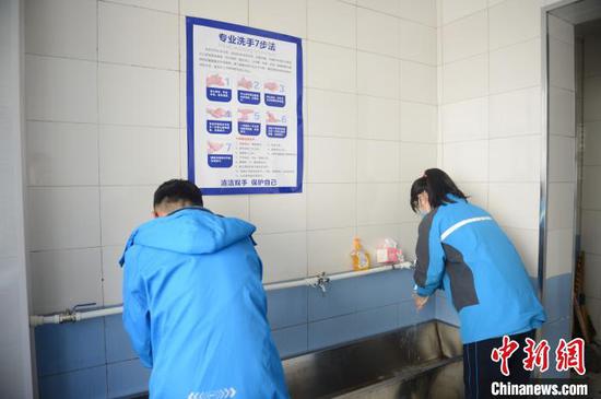 3月30日，学生在水房洗手，醒目位置贴着洗手7步法。　刘文华　摄