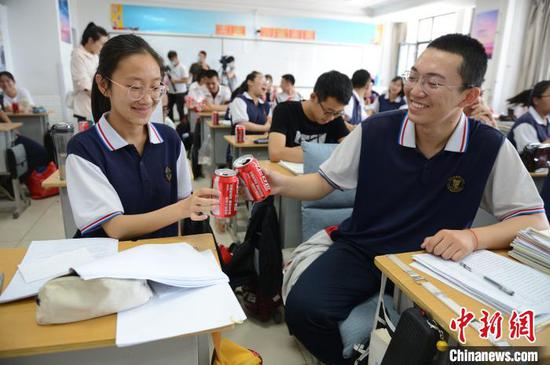 6月23日，高三年级学生互相碰杯，定制的饮品印有“祝金榜题名”。　刘文华 摄