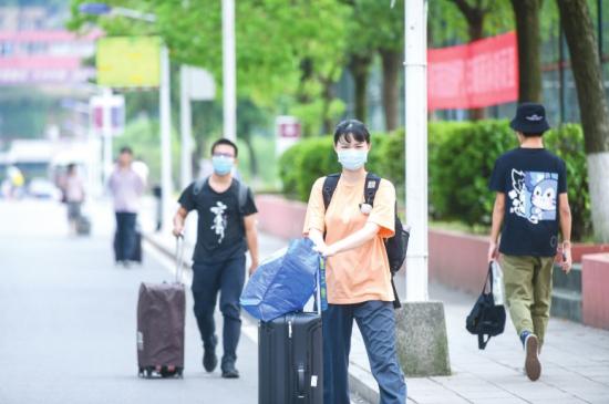 返校的学生拖着行李箱走在回宿舍的路上。