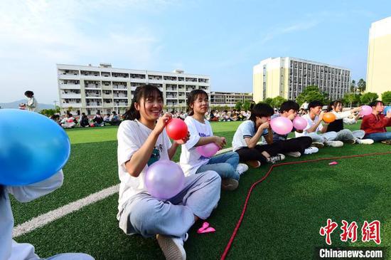 4月13日，江西省赣州市会昌县第三中学高三学生通过合力吹气球进行减压。　朱海鹏 摄