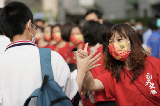6月7日，在北京市陈经纶中学考点外，送考老师（右）为即将进入考点的考生加油鼓劲。新华社记者 鞠焕宗 摄