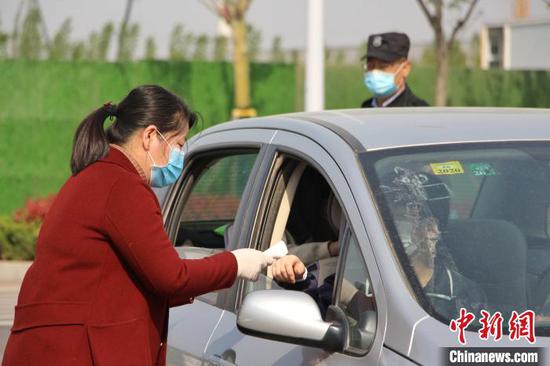 图为济南市历城二中的老师在对返校学生进行体温检测。 赵晓 摄