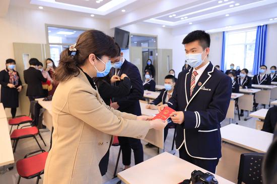 校长向学生赠送中华人民共和国宪法读本。广渠门中学供图