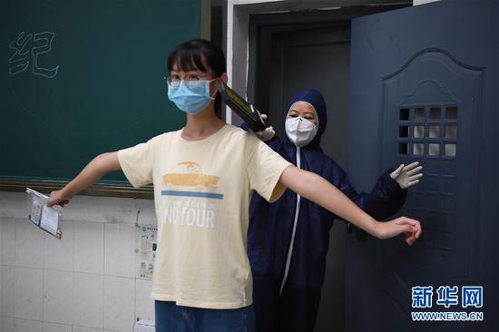 7月3日，工作人员（右）模拟为发热考生进行安检。 新华社记者 薛宇舸 摄