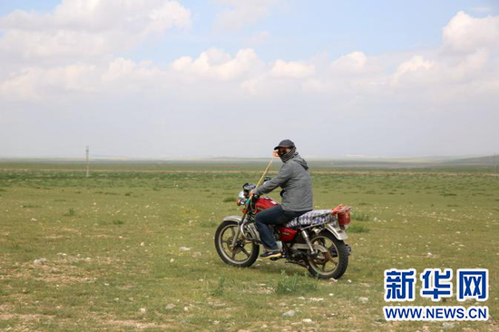 在草原上放马牧羊，很多时候要骑摩托。新华网 石毅摄