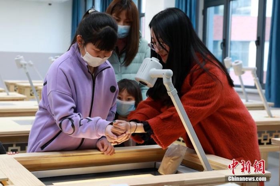 资料图：小朋友们在河北雄安容和乐民小学沙画教室体验沙画创作。 中新社记者 韩冰 摄
