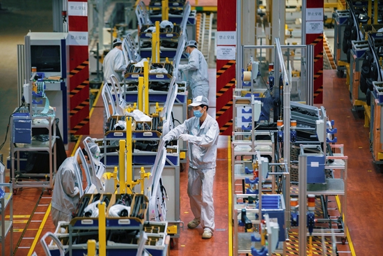 2020年2月20日，在广汽新能源汽车工厂，工人们正忙碌着组装车辆。视觉中国供图