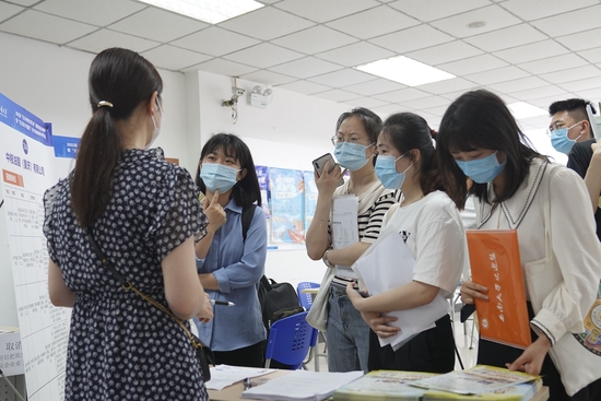 2022年5月13日，在位于重庆市北碚区的西南大学，应届毕业生在“百万英才兴重庆”招聘会上了解招聘信息。新华社记者 秦廷富 摄