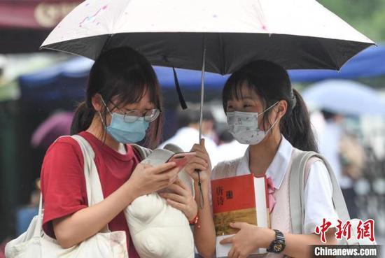 浙江高考结束首日，在杭州学军中学门口，考生抱着复习资料准备回家。　王刚　摄