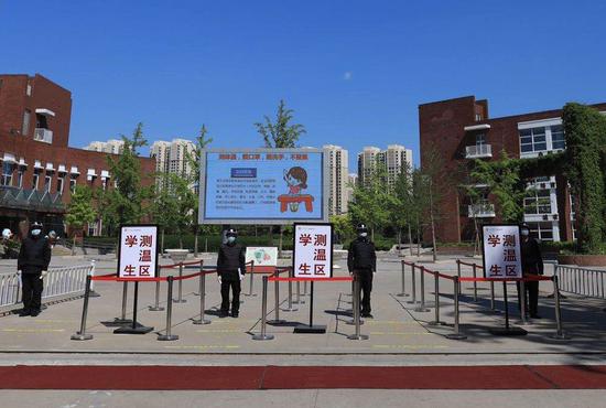 4月26日，北京外国语大学附属外国语学校门口设立通道，迎接高三学生复课。