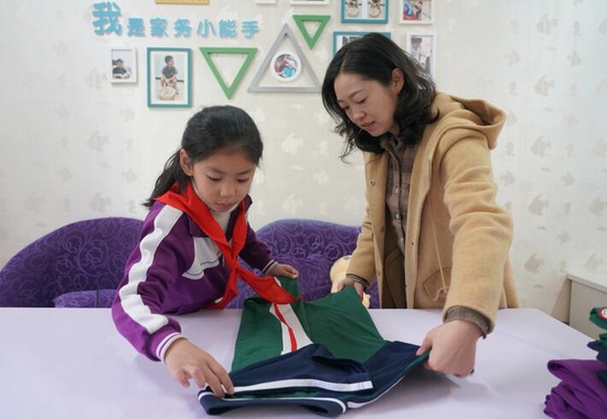 2021年11月10日，陕西平利县城关第三小学3年级1班的学生在学校内务整理室内学习叠衣服。 新华社记者 邵瑞 摄