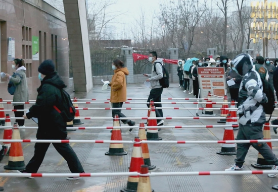 12月25日，2022年全国硕士研究生招生考试开考，考生在陕西省西安市的西安医学院考点外等待入场。图/中国新闻图片网