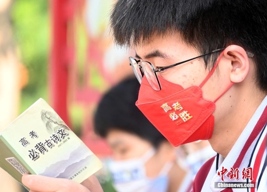资料图：戴着“高考必胜”口罩的考生正在温习古诗文。中新社记者 翟羽佳 摄