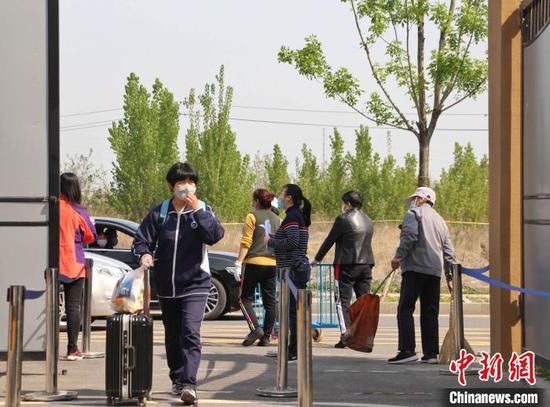 图为寄宿学生结束“超长寒假”,拖行李箱返校。 赵晓 摄