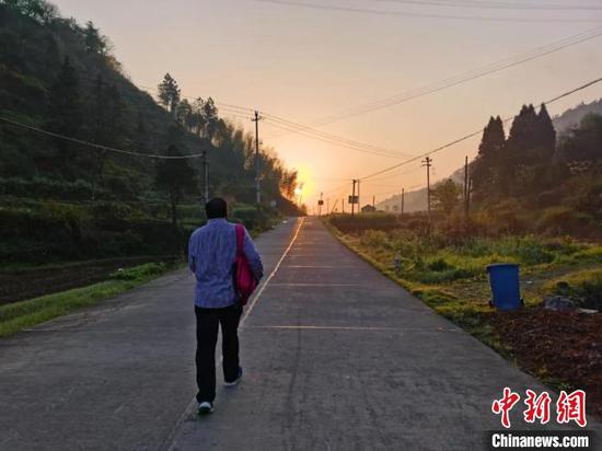 王金良又一次背上书包,走上前往孩子家中的路。 叶路顺 摄