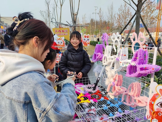 ↑雨点热情地向游客介绍自己售卖的小饰品