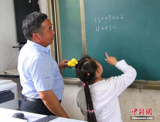 杨少成教学生做数学题.梁俊 摄