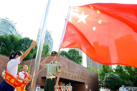 4名少先队员护旗手在上海市黄浦区中共一大会址护送五星红旗.