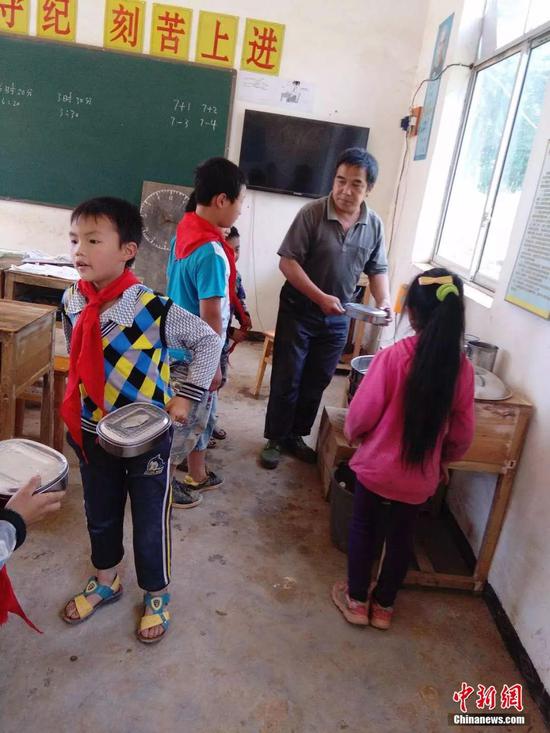 资料图,杨少成给学生热饭.受访者供图