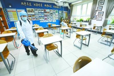 昨天上午，在北京十一学校高三年级教室，保洁人员在为教具、桌椅、地面进行消毒，准备迎接高三学生开学。本报记者 饶强摄
