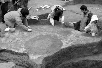 北大考古专业学生在周公庙遗址实习时，清理一个史前房址的地面与灶坑。