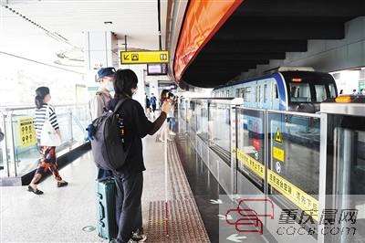 邬舜仙在工作人员的帮助下乘坐轻轨。