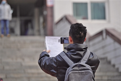 北方工业大学考点，一名考生在考点外拍照留念。