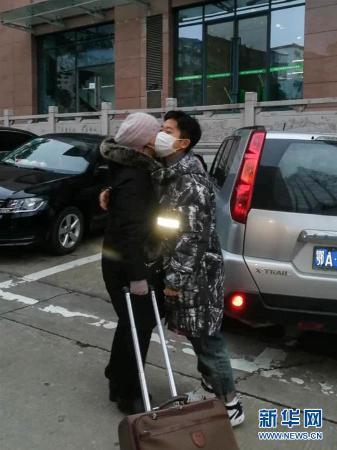 谭艺西（右）和即将前往抗疫一线的妈妈拥抱告别（1月27日摄）。　新华社发