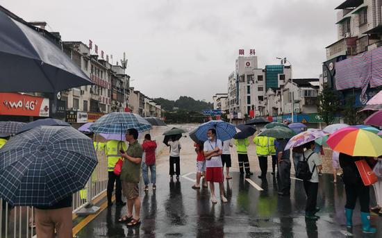 7月7日，河道洪水漫上街道，警方在现场维持秩序。受访者供图