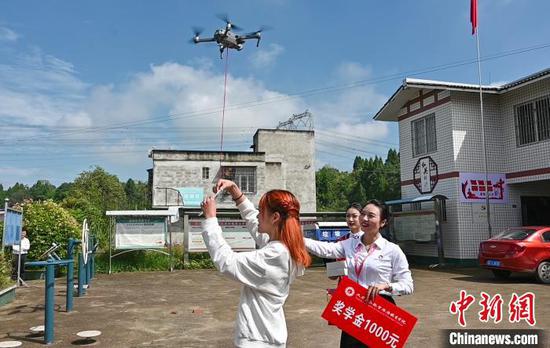 李浩岚（左）从无人机上取下录取通知书。　天府新区航空旅游职业学院供图 